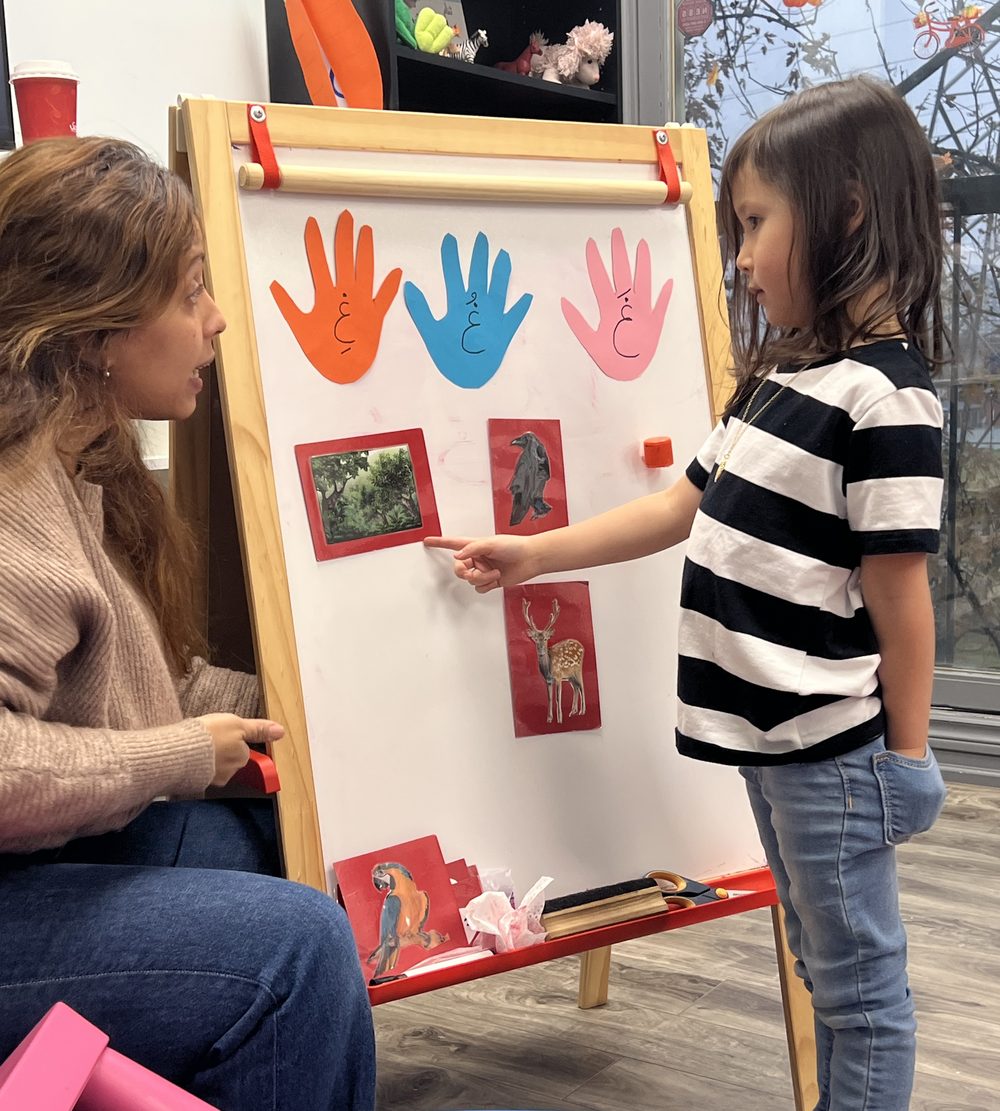An Arabeez teacher and a student working together at the easel