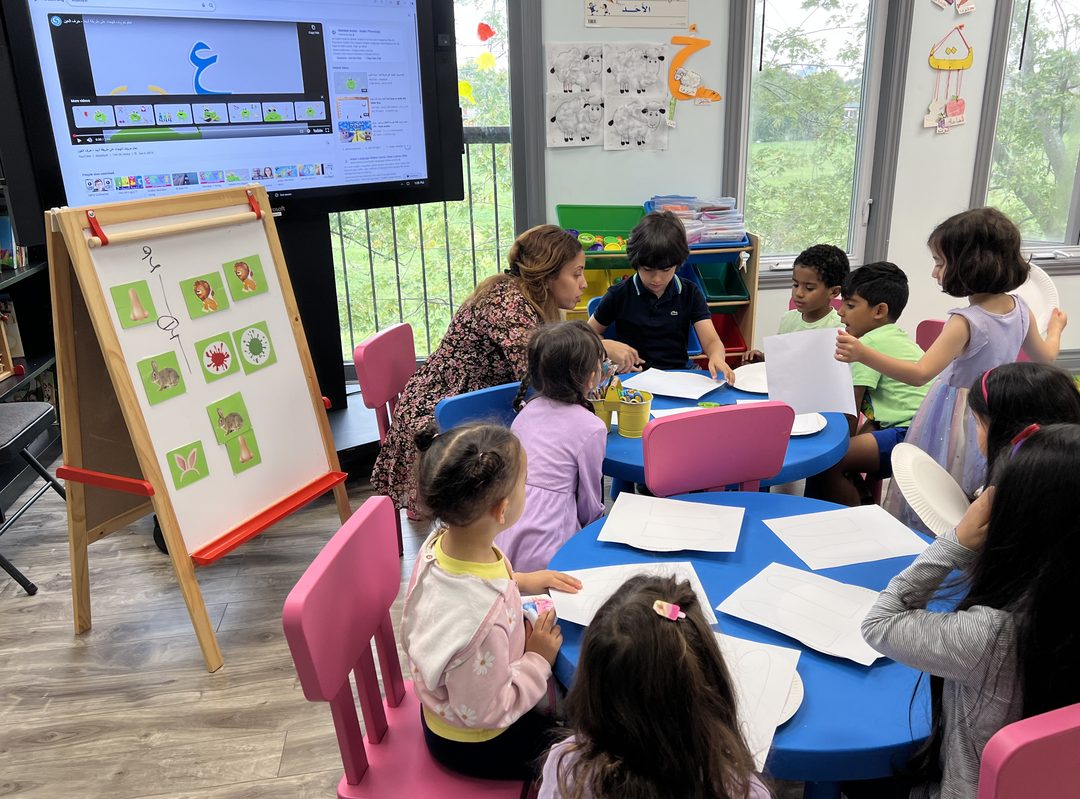 An Arabeez teacher with a class of children working together at their tables