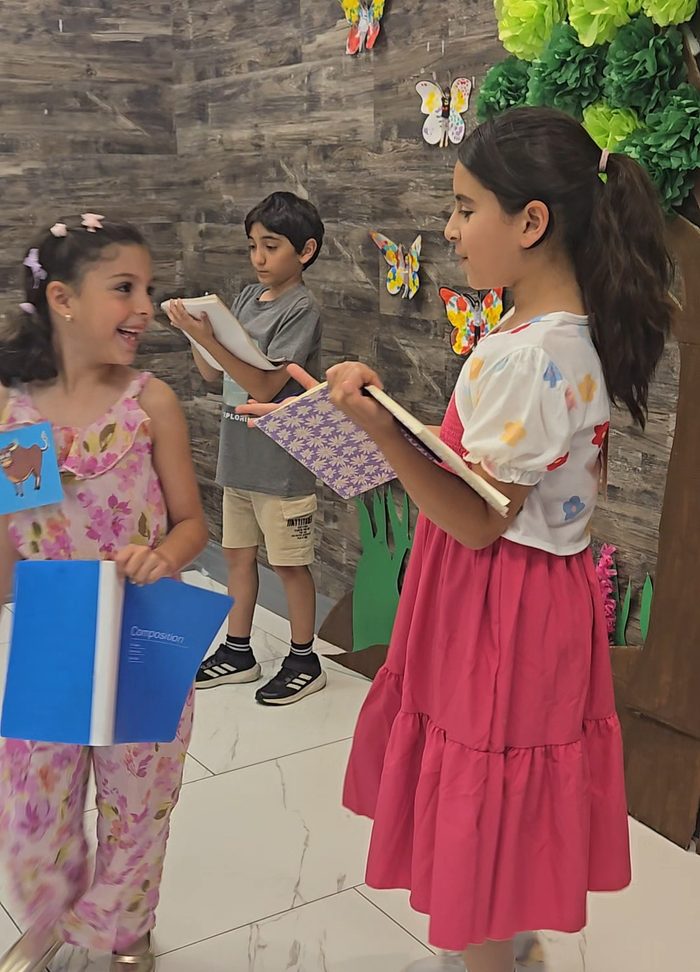 An older Arabeez student reading Arabic aloud to two younger classmates
