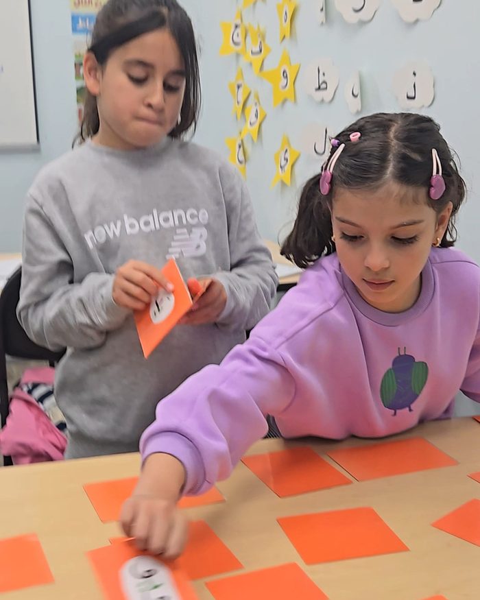 Two Arabeez students matching Arabic letter cards at their table